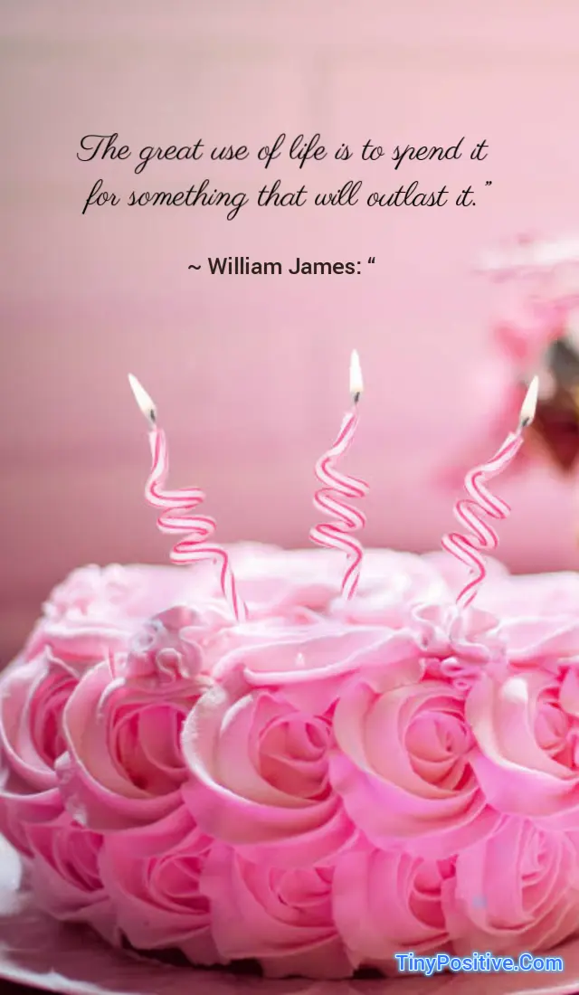 An inspirational quote graphic set against a soft pink background featuring a frosted pink cake decorated with piped rose swirls and three lit spiral-striped birthday candles. In the upper portion, black cursive script text reads: 'The great use of life is to spend it for something that will outlast it.' Below the quote, the attribution reads: '~ William James: “ The TinyPositive.Com watermark is visible in blue text at the lower right corner.